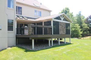 Timbertech PVC American Walnut deck, A-frame screen room with open gable, gas fireplace. custom bartop on railing and stone columns &#8211; Bluebell PA