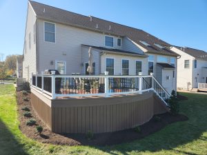 Timbertech PVC English Walnut deck with matching skirting around bottom, white vinyl rails with black aluminum balusters and English Walnut drink rail &#8211; Reading PA