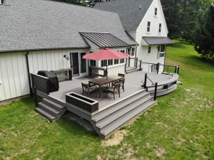 Timbertech PVC Dark Hickory deck with Coastline border, curved front with custom benches and bar top &#8211; Chadds Ford PA