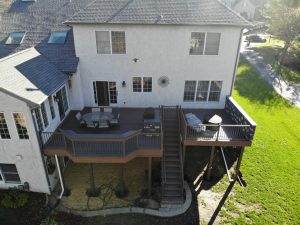 Timbertech PVC Dark Hickory deck with English Walnut border, Bronze American series aluminum railings, stone veneer outdoor kitchen and privacy wall &#8211; Hockessin DE